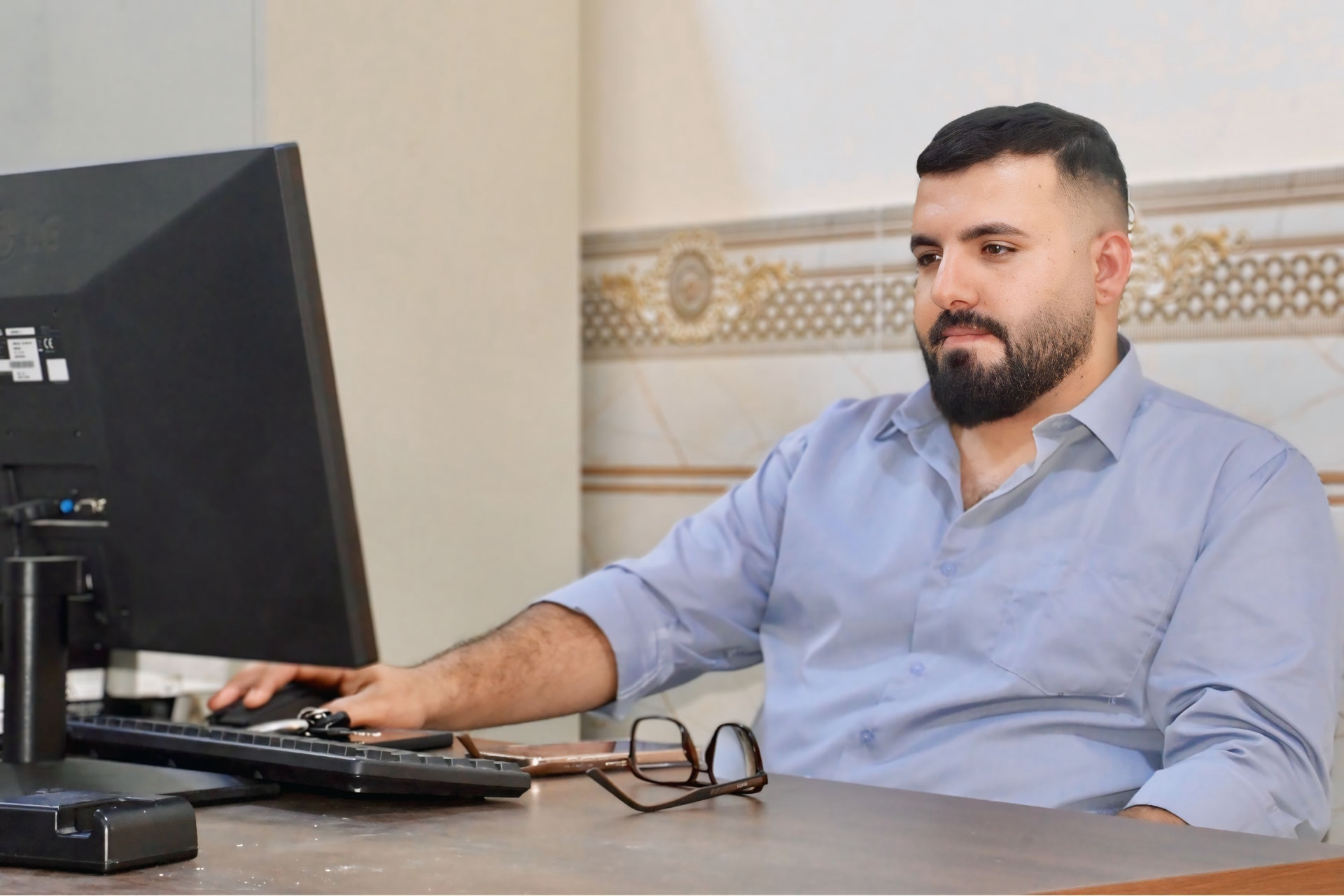 Research site staff member reviewing site profile information at a computer workstation