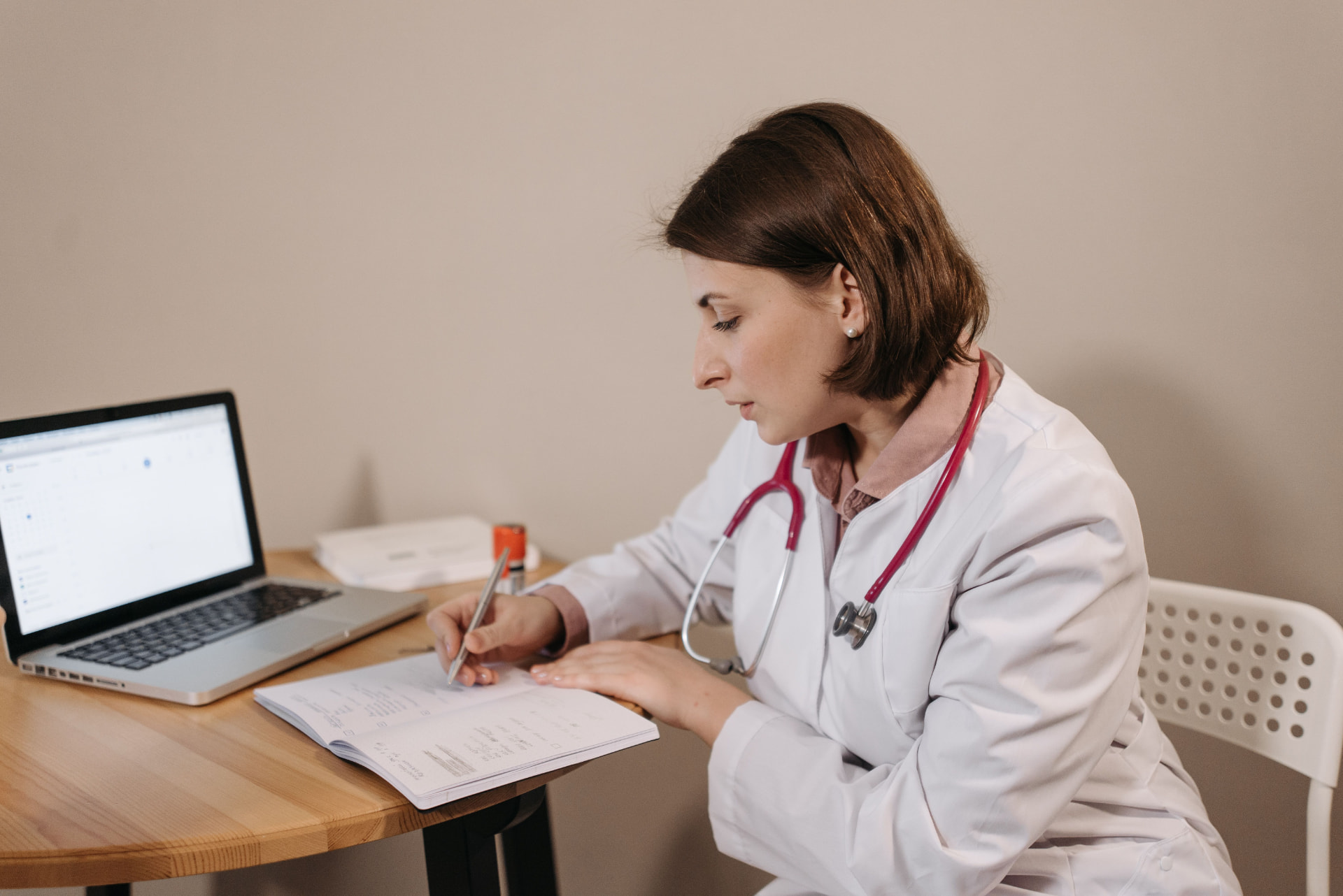 Clinical researcher reviewing a structured clinical trial protocol document alongside study data on a laptop